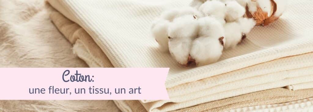 Pile de tissus naturels écrus avec une fleur de coton posée dessus, avec le texte