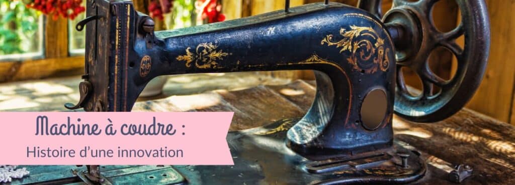 Vieille machine à coudre en métal bleu décorée de motifs dorés, posée sur une table en bois, illustrant l’histoire de l’innovation dans la couture.