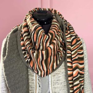Chèche femme réversible kaki saumon, grand foulard triangle en tissu rayé et doublure sweat matelassée, mannequin sur fond rose.