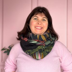 femme portant un tour de cou au motif imprimé flora dans les teintes de noire et rose