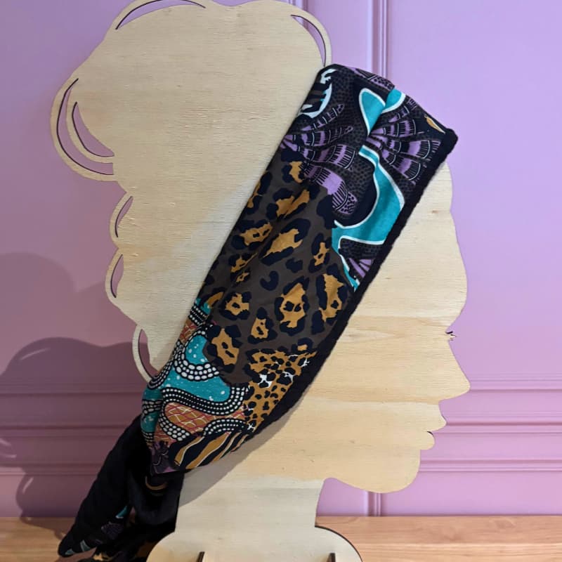 Foulard Sophie Scarf version hiver portรฉ en bandeau sur une silhouette en bois, tissu en laine tressรฉe et viscose ร motifs colorรฉs.