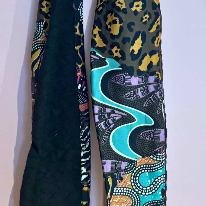 Dรฉtail des tissus du foulard Sophie Scarf, mรฉlange de laine noire et de viscose ร motifs ethniques colorรฉs.