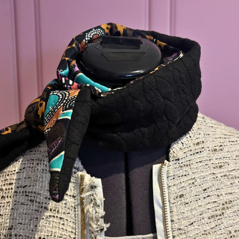 Foulard Sophie Scarf noir en laine tressรฉe et viscose imprimรฉe, nouรฉ autour du cou sur un mannequin.