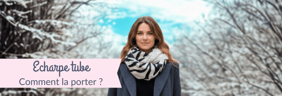 Femme marchant en hiver au milieu d’arbres enneigés, portant une écharpe tube zèbre et un manteau gris, avec le texte « Écharpe tube – Comment la porter ? »