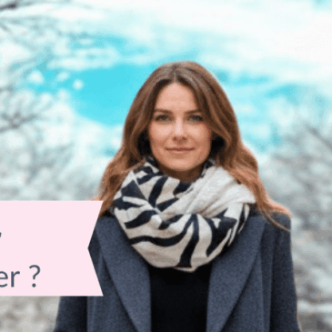 Femme marchant en hiver au milieu d’arbres enneigés, portant une écharpe tube zèbre et un manteau gris, avec le texte « Écharpe tube – Comment la porter ? »