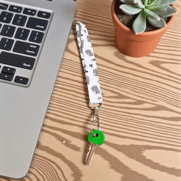 porte clé dragonne avec une clé verte posée sur un bureau - Maison Pivoine